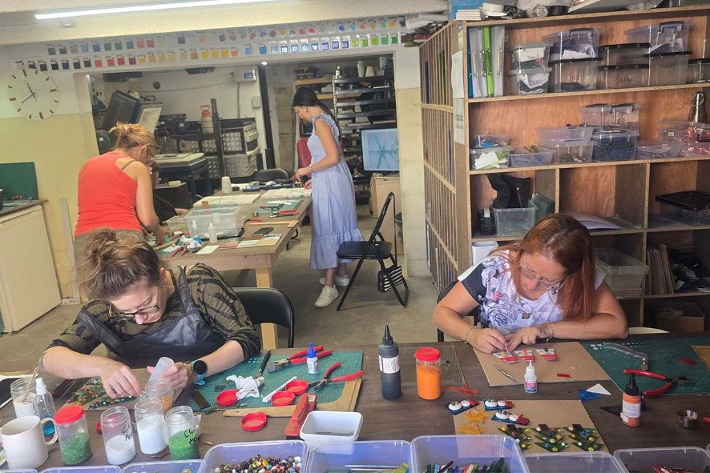 Members creating glass art at shared studio work tables