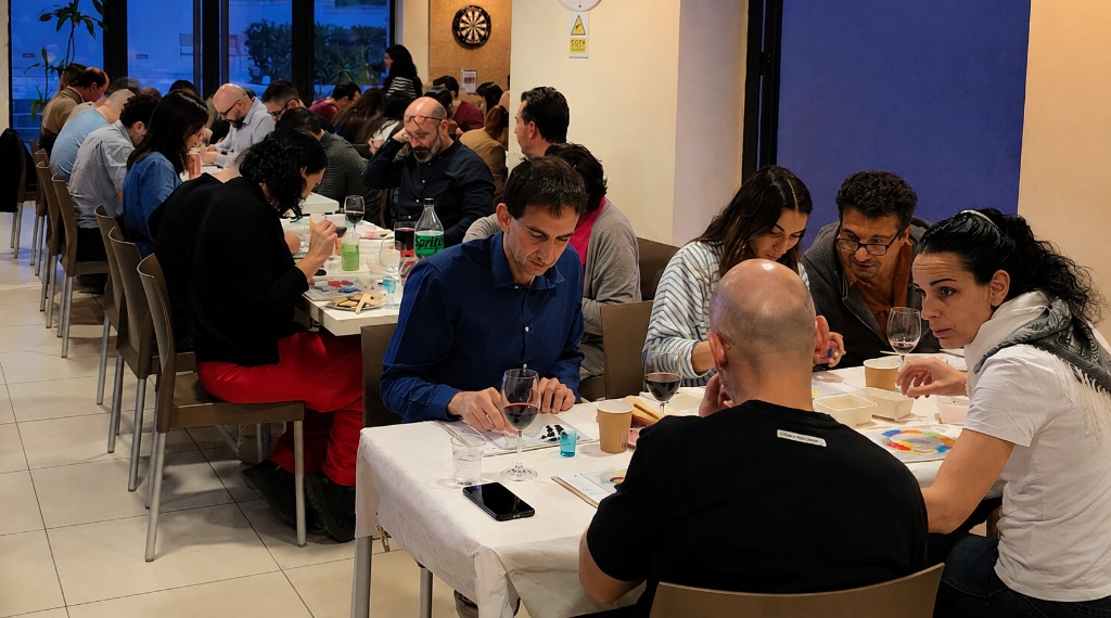 Large group enjoying a tailored creative team-building workshop at shared tables